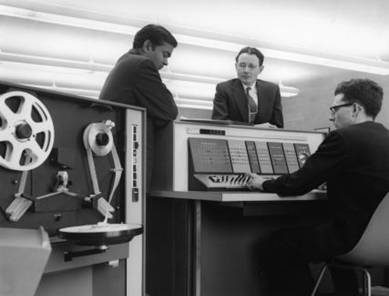 Kesavan, Myers and Lawson are shown left to right with the IBM 1620 equipped with a paper tape reader.