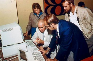 Wes Graham, Shirley Fenton, Eric Mackie and Don Cowan using a Personal Computer and portable computer on the ARIES network