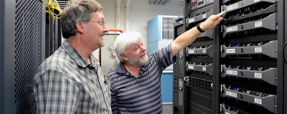 Two staff members (Dan and Dave) are looking at a server rack.