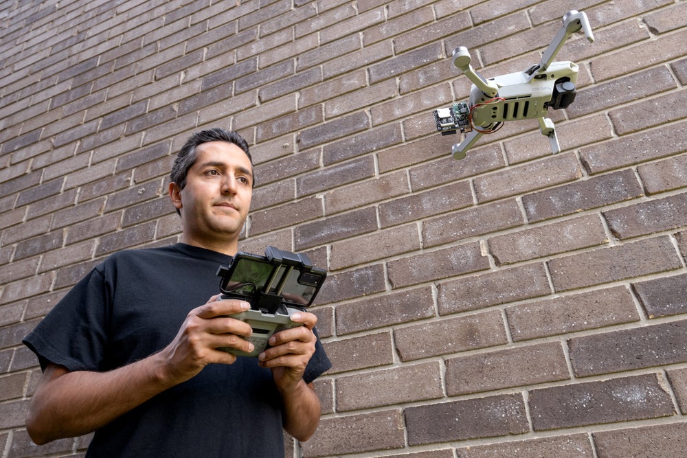 photo of Ali Abedi demonstrating Wi-Peep device on a drone
