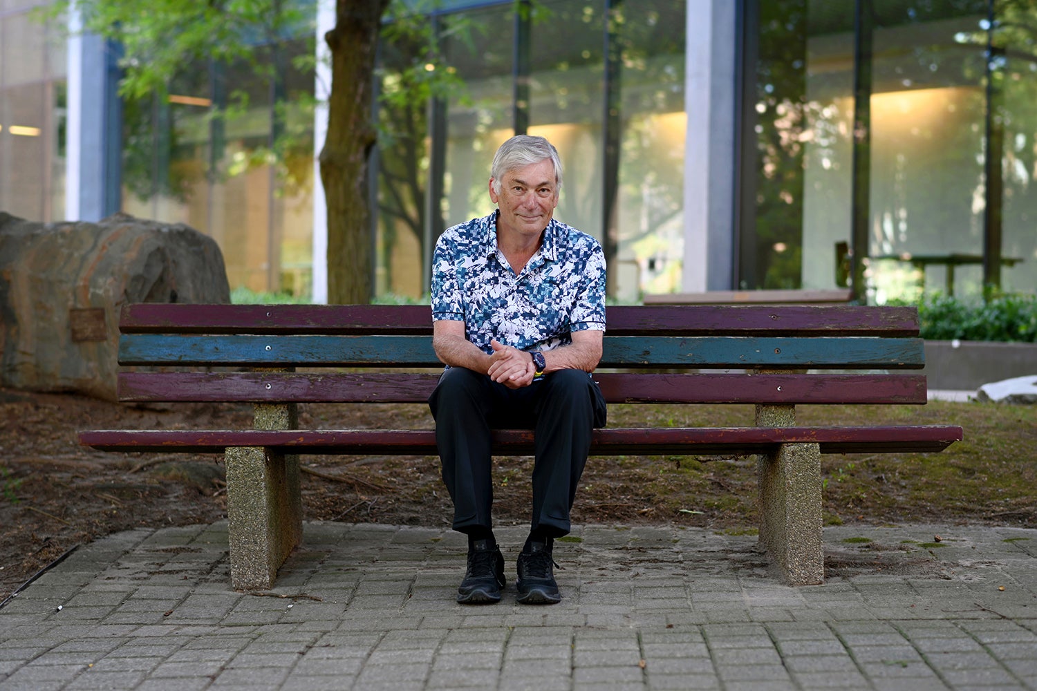photo of  Distinguished Professor Emeritus Ian Munro on bench in Waterloo's rock garden