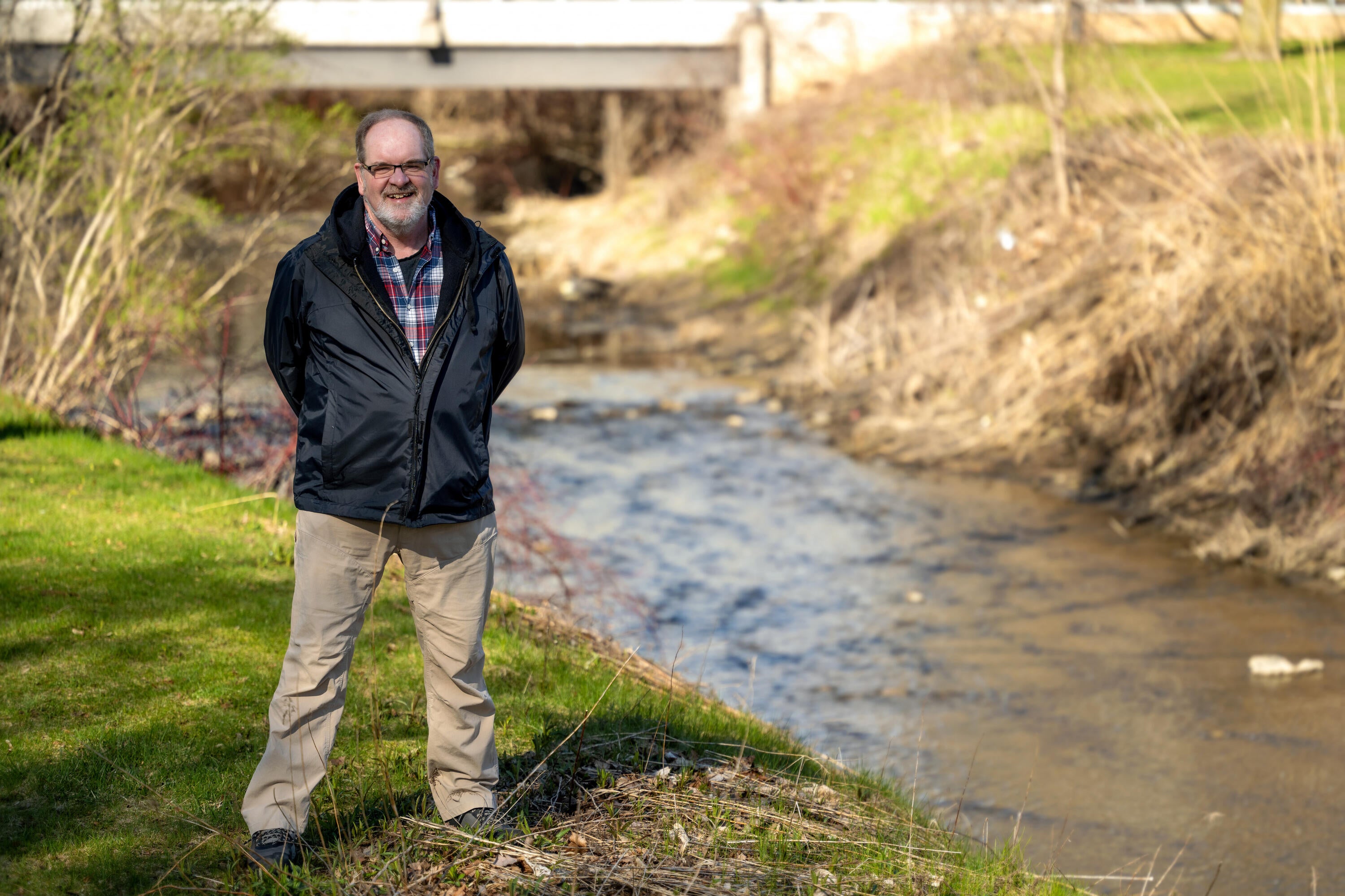 Photo of Doug Mulholland posing in front of a stream