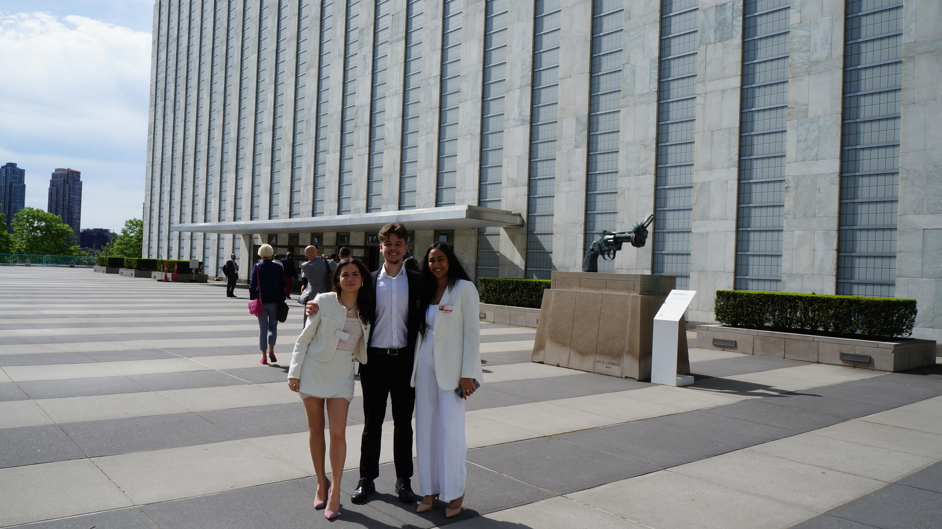 photo of the founding members wearing business-casual outfits. They are standing outside in front of the UN building