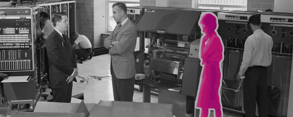 a black and white photo of 4 people: 3 men. but the women's silhoutte is in pink. theyre surrounded by computers