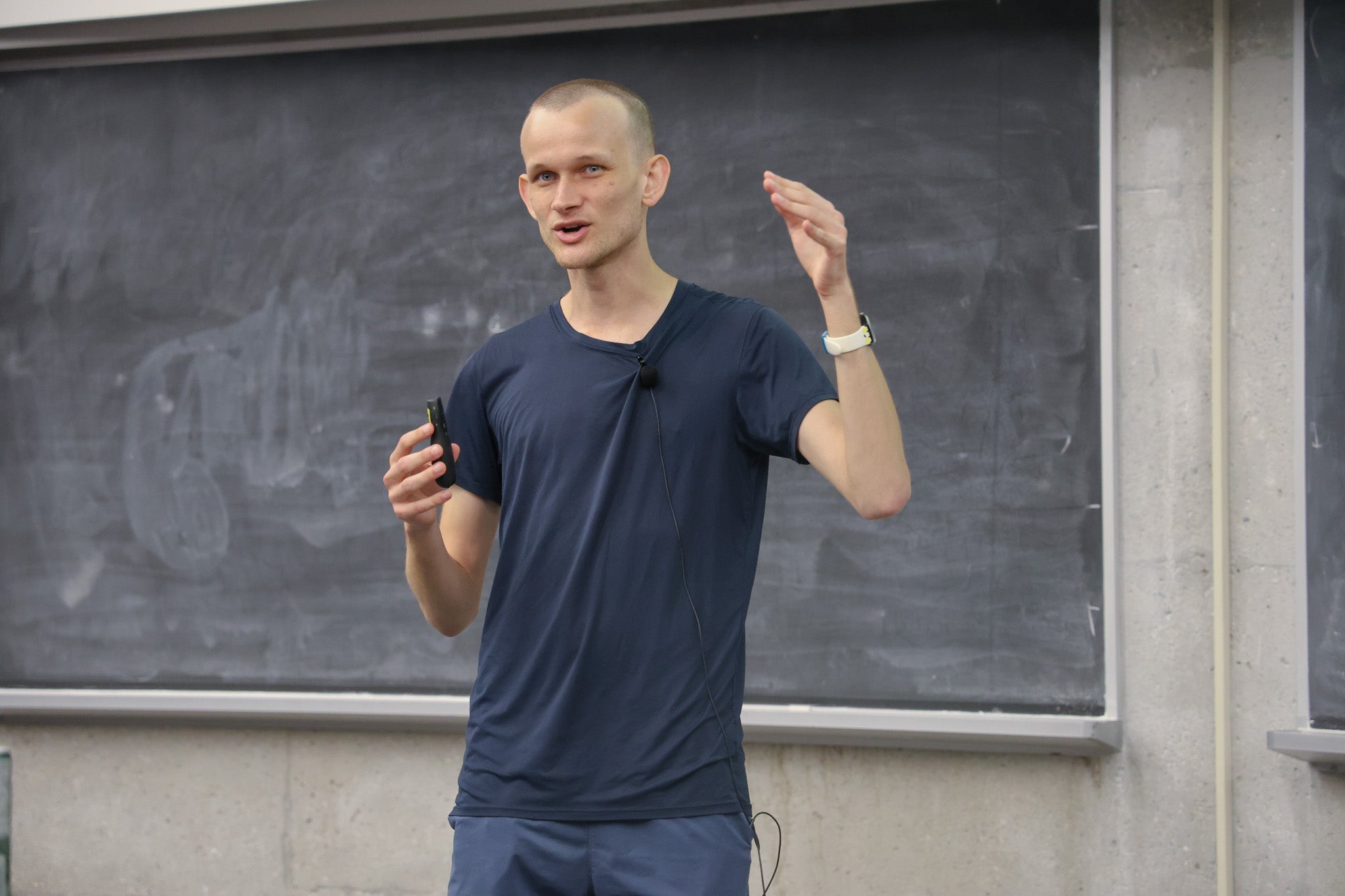 Photo of Vitalik Buterin at the Math Innovation Event. He is standing in front of a chalk board