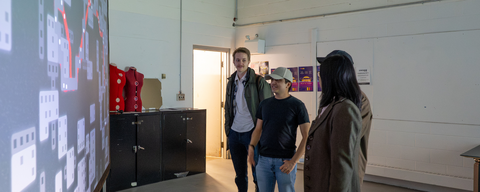 Four people standing in front of a screen depicting Desire Paths