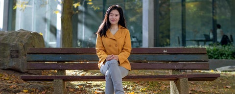 Professor Xioa Hu on bench in Waterloo's rock garden