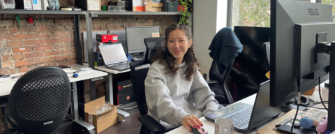 saralin holding a mouse in her office/artist studio