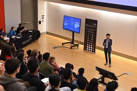 Rastin presenting in front of a panel of judges and crowd at the Velocity Semi Finals