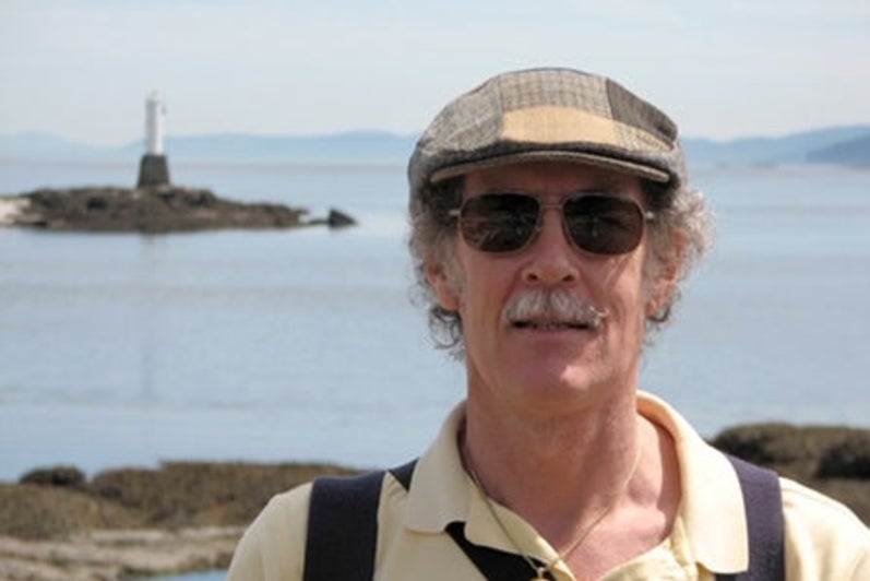 John Beatty and his younger poodle Sparky walking on the beach at Sandwell Provincial Park on Gabriola Island
