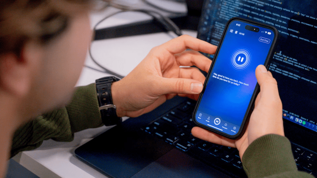 Close-up of someone holding a phone. The screen is blue and it reads "Hey good to have you back. How much time do you have for us today?""