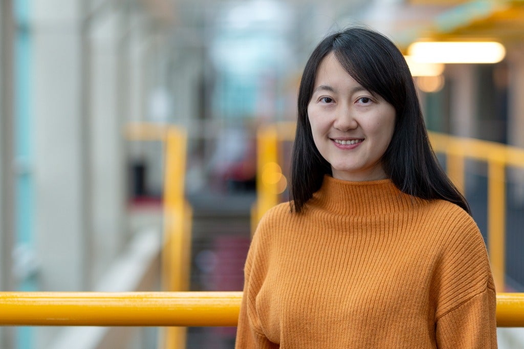 Professor Xi He donning a yellow-orange sweater inside DC