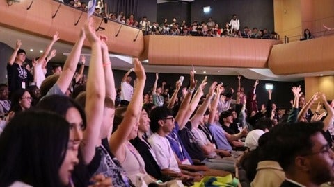 Audience members raising their hands up