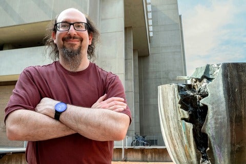 Professor Ian Goldberg stands beside Break, a campus landmark, with MC in the background