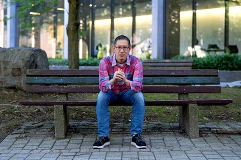 Professor Jimmy Lin on bench in Waterloo's rock garden