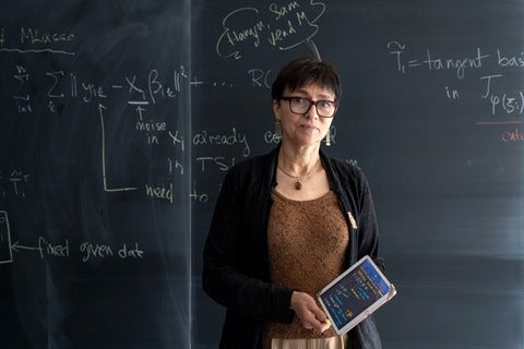 Professor Marina Meila in front of a blackboard with text and equations