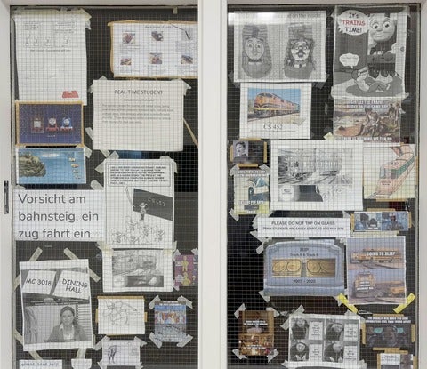photo of the wall of memes on the window outside CS452, the trains lab