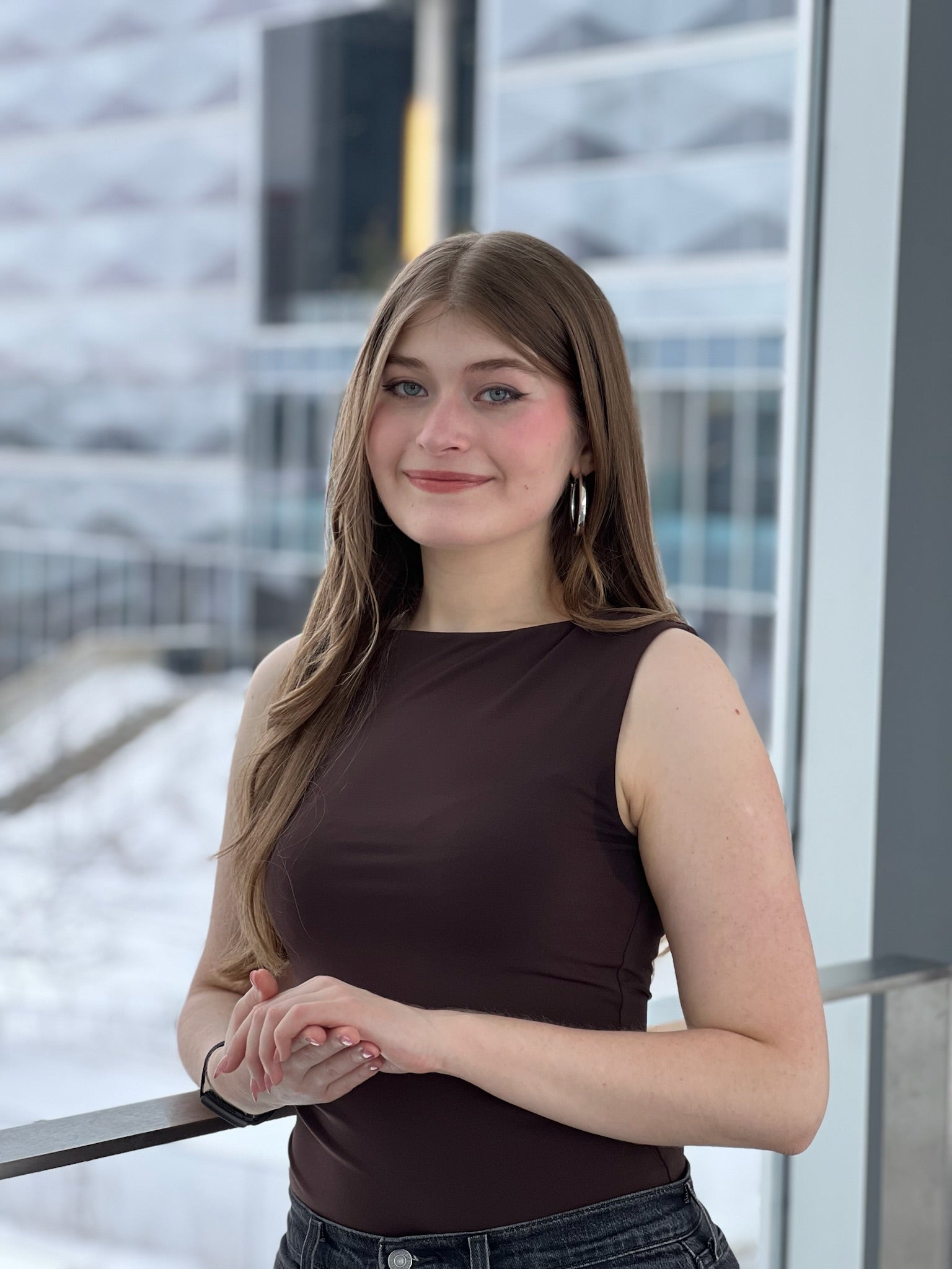 A woman in a sleeveless brown shirt posing inside Engineering 7 