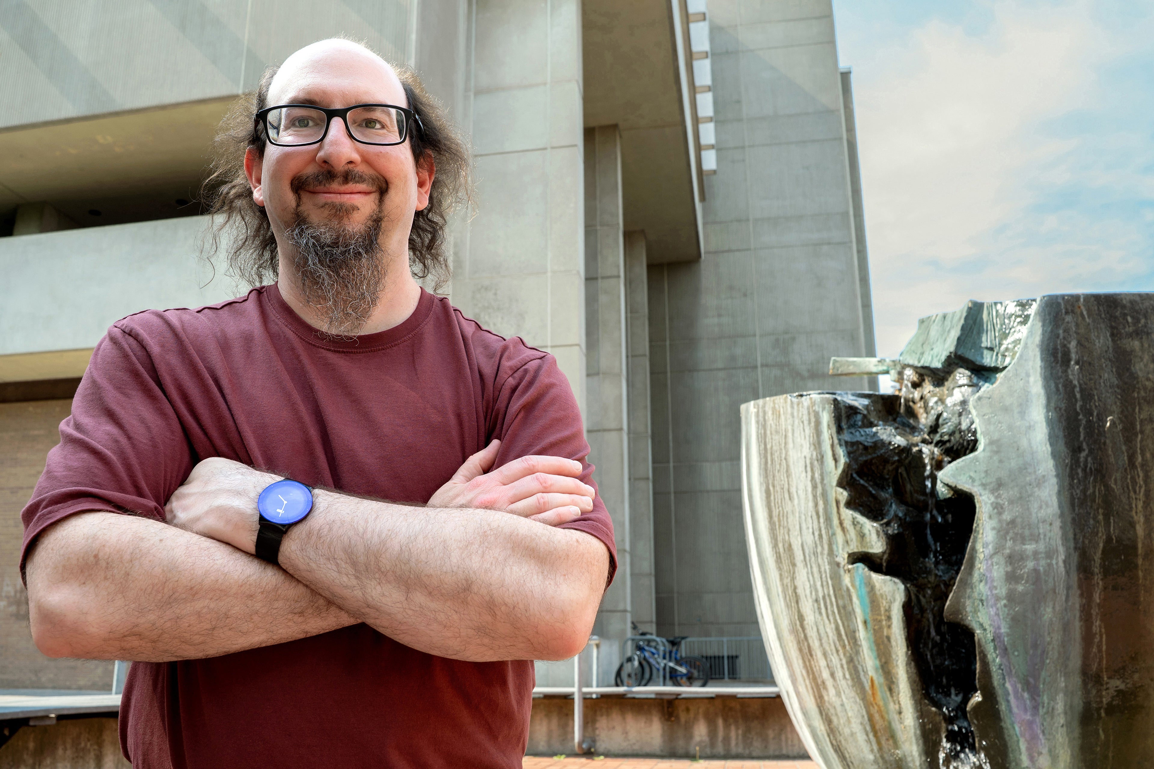 Professor Ian Goldberg stands beside Break, a campus landmark, with MC in the background