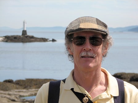 John Beatty and his younger poodle Sparky walking on the beach at Sandwell Provincial Park on Gabriola Island