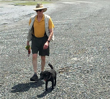 John Beatty and his younger poodle Sparky walking on the beach at Gabriola Island