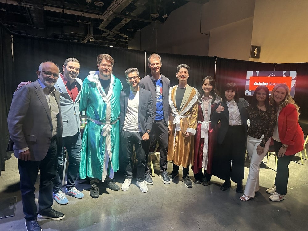 A group of people in suits and robes taking a group shot at a conference's backstage