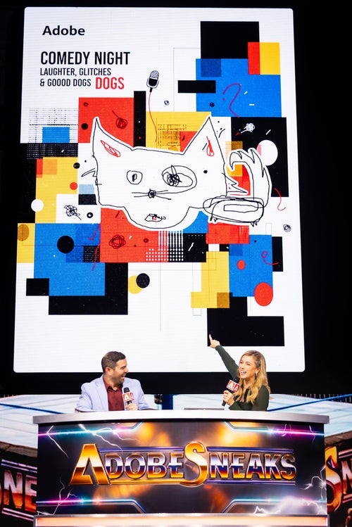2 people (a brunette man and a blonde woman) sitting on a large desk. Above them is a screen of an illustration with huge block designs. In the middle is a cartoon of a dog